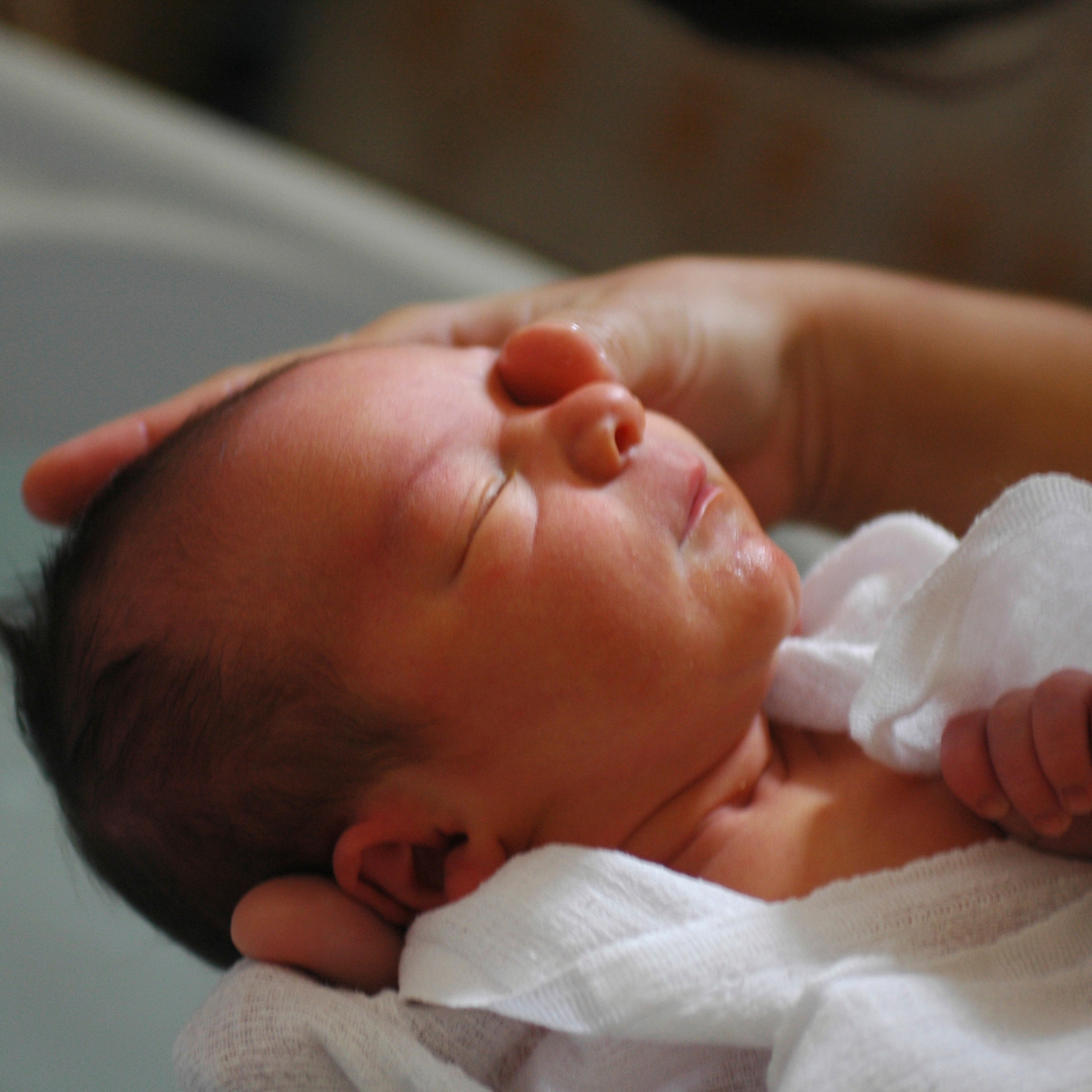 Zufriedenes Baby, das von seinen Eltern gebadet wird Zufriedenes Baby, das von seinen Eltern gebadet wird