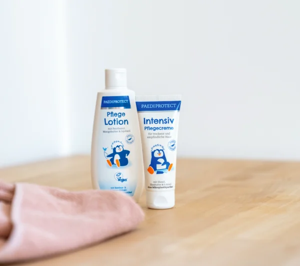 PAEDIPROTECT Pflegelotion + Intensiv Pflegecreme auf ein Holz Tisch