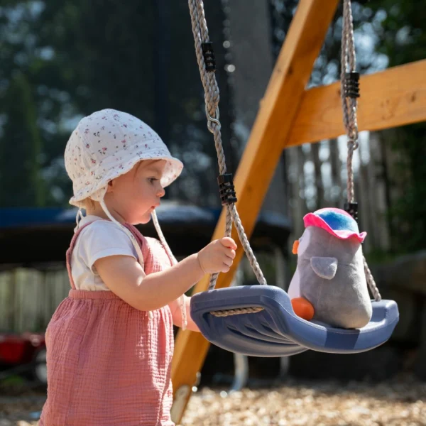 a baby girl holding a swing