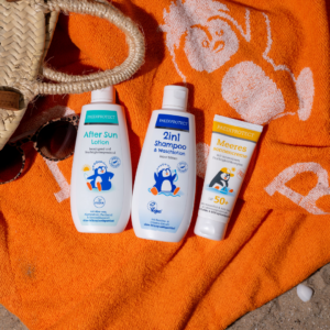 Meeressonnencreme, 2in1 Shampoo & Waschlotion, die After Sun Lotion auf dem Pauli-Badetuch auf den Sand gelegt