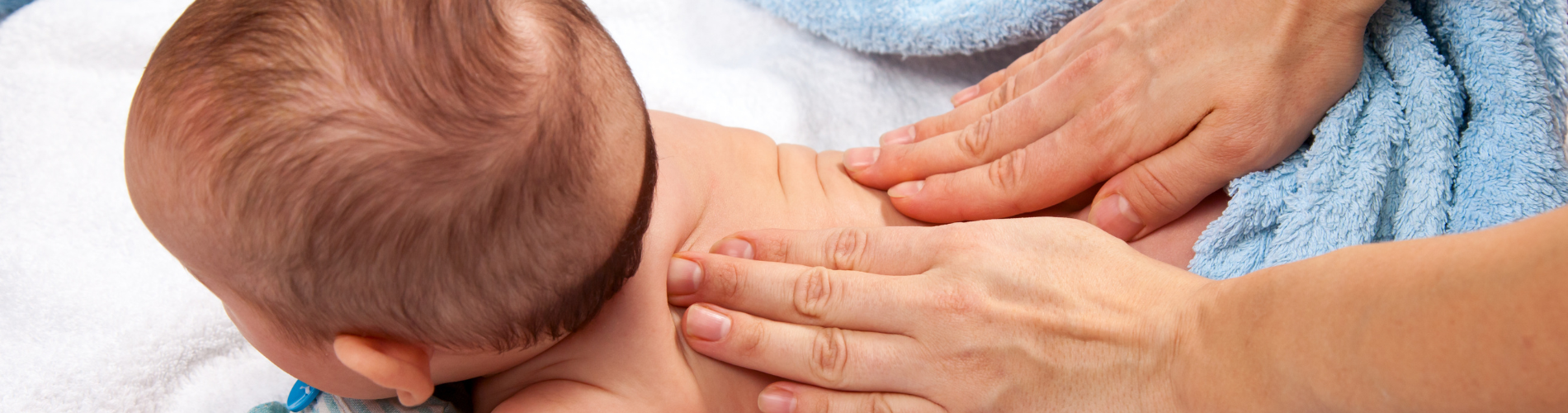 baby massage a close-up of hands massaging a baby's back